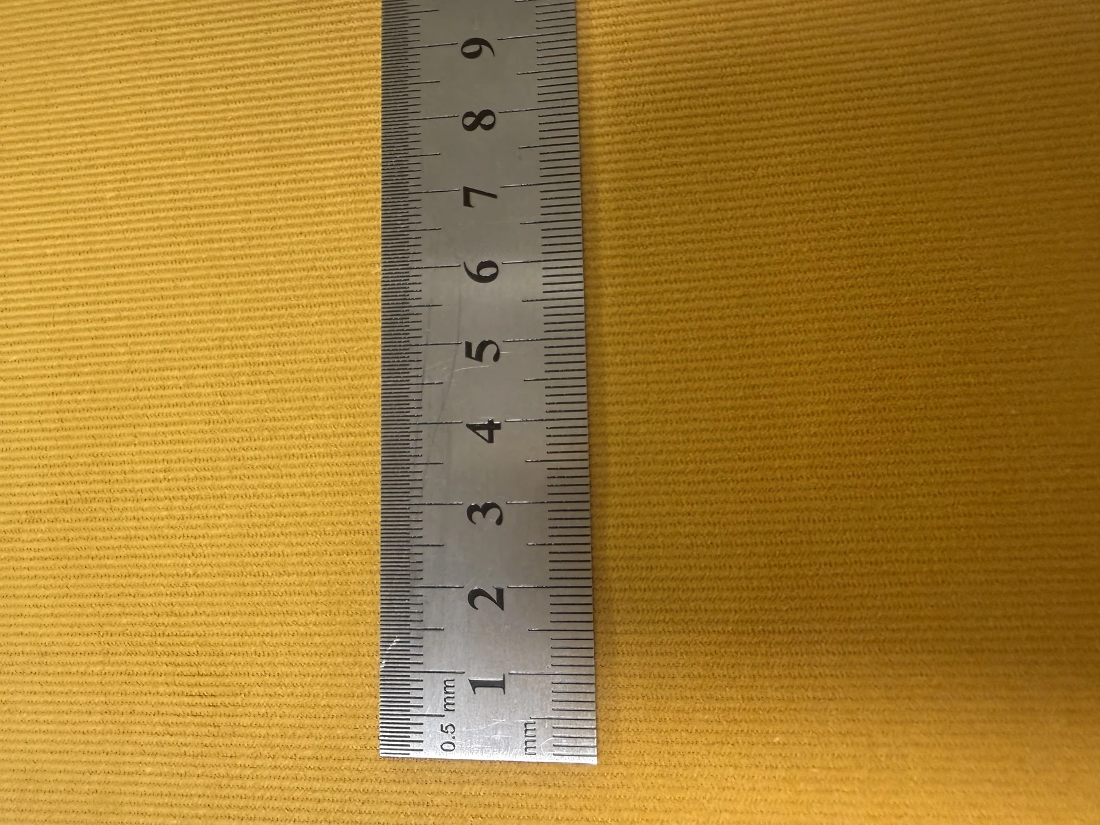 Corduroy pile detail close-up — mustard yellow